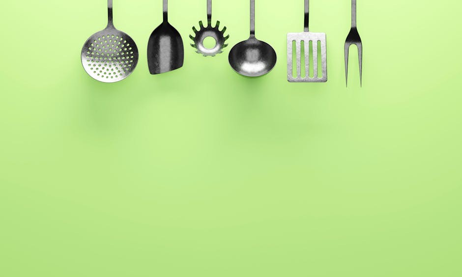 A set of hanging kitchen utensils against a vibrant green background, perfect for culinary themes.